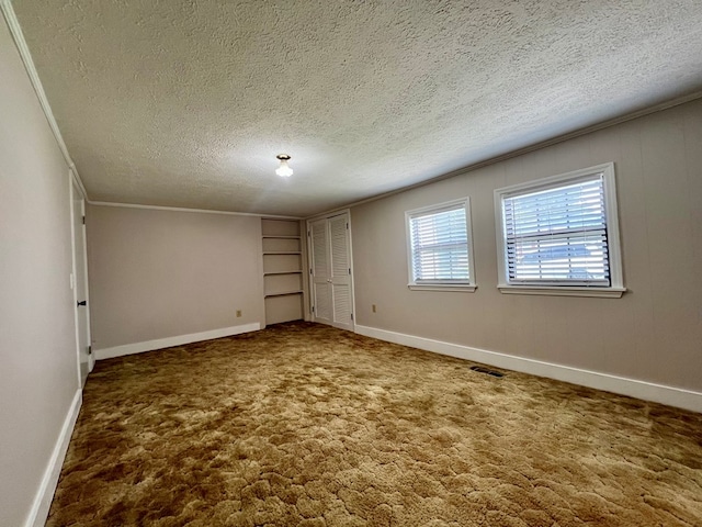 interior space featuring baseboards, a textured ceiling, and visible vents