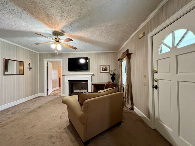 carpeted living room featuring a textured ceiling, ornamental molding, a fireplace, and ceiling fan