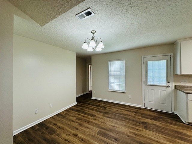 122 Ericas Ct, Fitzgerald, GA 31750 - unfurnished dining area featuring a chandelier, dark wood-style floors, and a textured ceiling