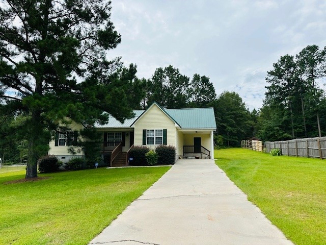 122 Ericas Ct, Fitzgerald, GA 31750 - ranch-style house with driveway, a carport, and a metal roof