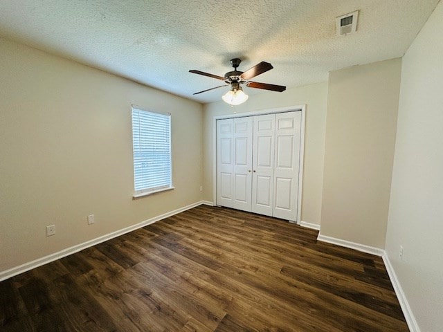 122 Ericas Ct, Fitzgerald, GA 31750 - unfurnished bedroom featuring dark wood-type flooring, a closet, a ceiling fan, and a textured ceiling