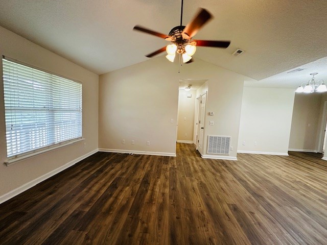 122 Ericas Ct, Fitzgerald, GA 31750 - empty room featuring lofted ceiling, a chandelier, a ceiling fan, wood finished floors, and a textured ceiling
