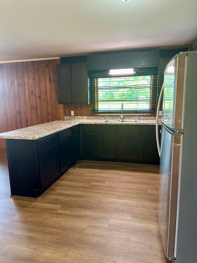 1222 Minton Rd, Sylvester, GA 31791 - kitchen featuring freestanding refrigerator, light wood-style flooring, a peninsula, wooden walls, and light stone counters