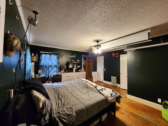 410 W Henderson St, Ocilla, GA 31774 - bedroom featuring baseboards, a textured ceiling, radiator, and wood finished floors