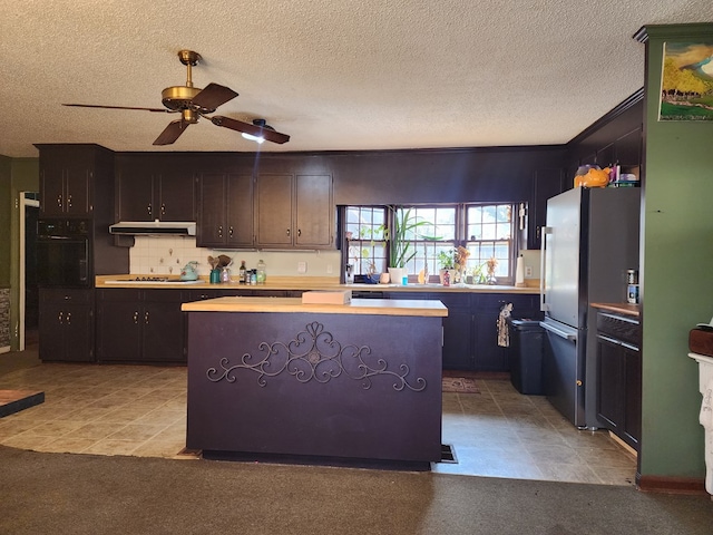 410 W Henderson St, Ocilla, GA 31774 - kitchen with oven, light countertops, a center island, freestanding refrigerator, and a ceiling fan
