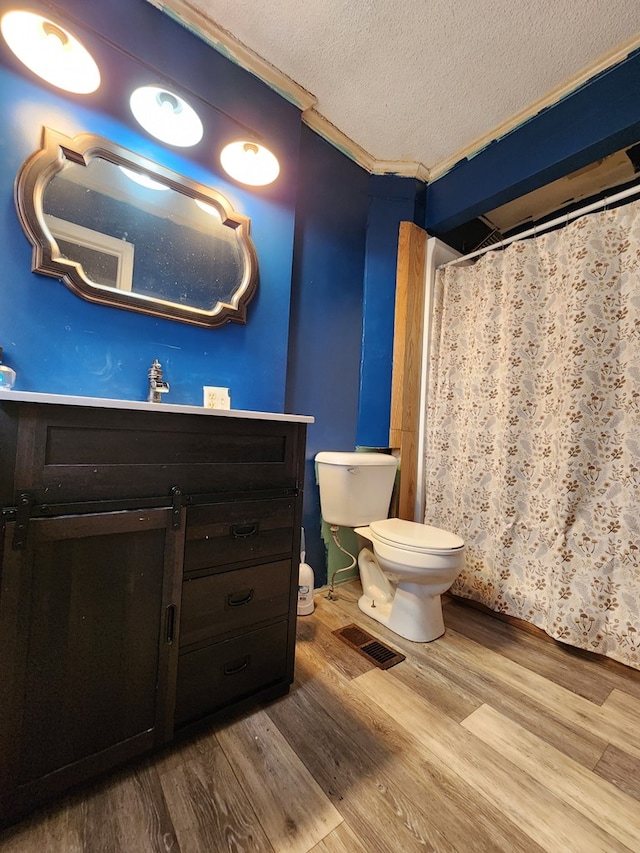410 W Henderson St, Ocilla, GA 31774 - bathroom featuring a textured ceiling, wood finished floors, vanity, toilet, and ornamental molding