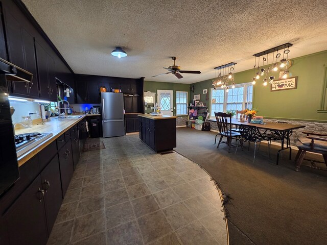 410 W Henderson St, Ocilla, GA 31774 - kitchen featuring a center island, a textured ceiling, appliances with stainless steel finishes, and ceiling fan