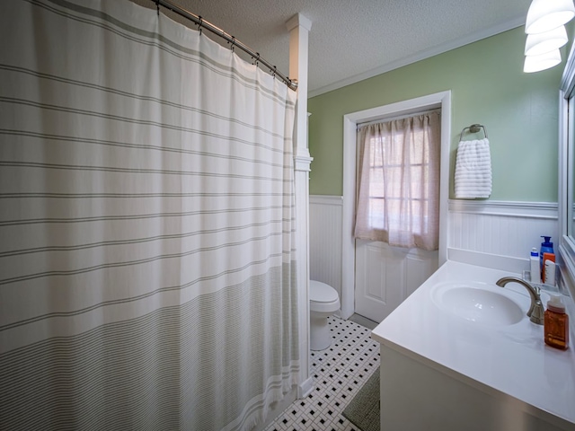 1447 Davis Ave, Tifton, GA 31794 - full bath with toilet, a textured ceiling, crown molding, vanity, and wainscoting