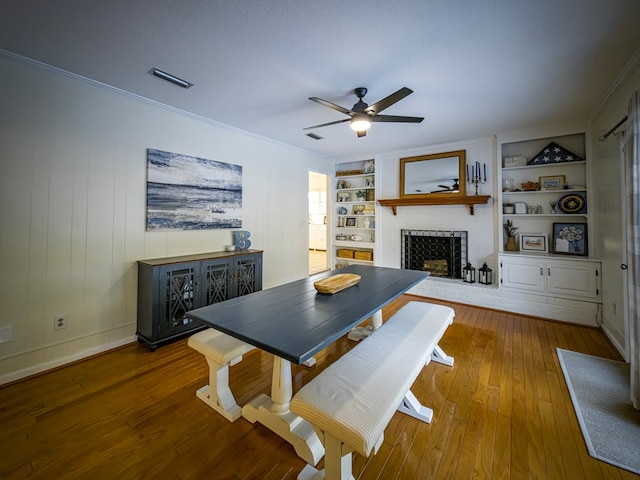 1447 Davis Ave, Tifton, GA 31794 - dining space featuring ornamental molding, built in shelves, a ceiling fan, a brick fireplace, and wood-type flooring