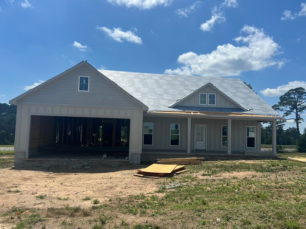 12 Edgewater Ct, Tifton, GA 31793 - rear view of property featuring an attached garage, board and batten siding, a porch, and dirt driveway