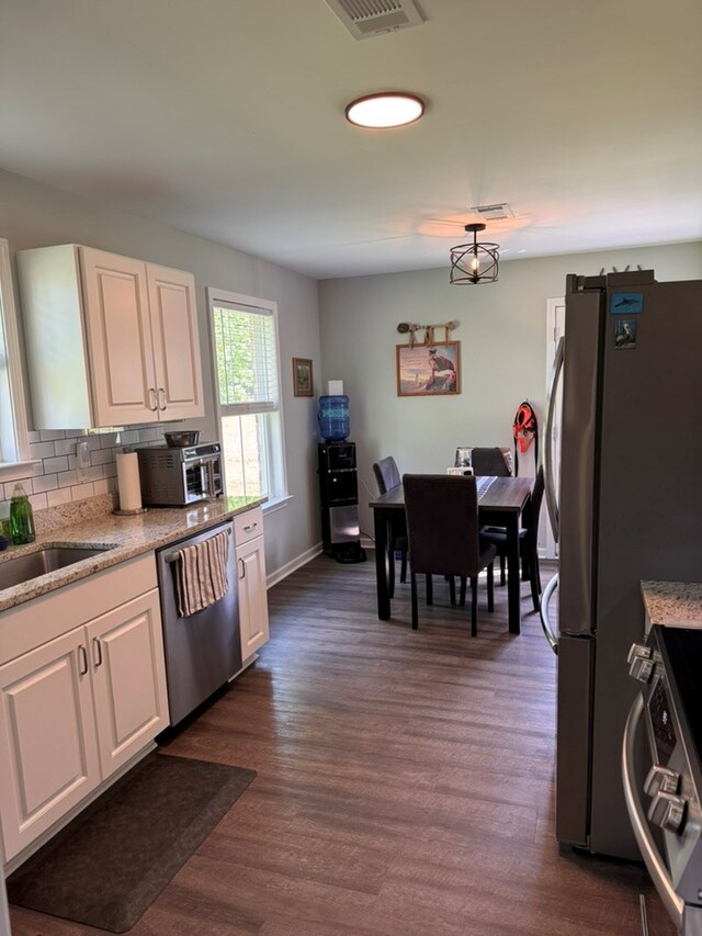 3524 Moss Island Ct, Albany, GA 31721 - kitchen featuring stainless steel appliances, white cabinetry, a sink, dark wood-type flooring, and backsplash