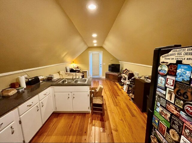 311 E 24th St, Tifton, GA 31794 - interior space with light wood-style flooring, white cabinets, a sink, dark countertops, and lofted ceiling