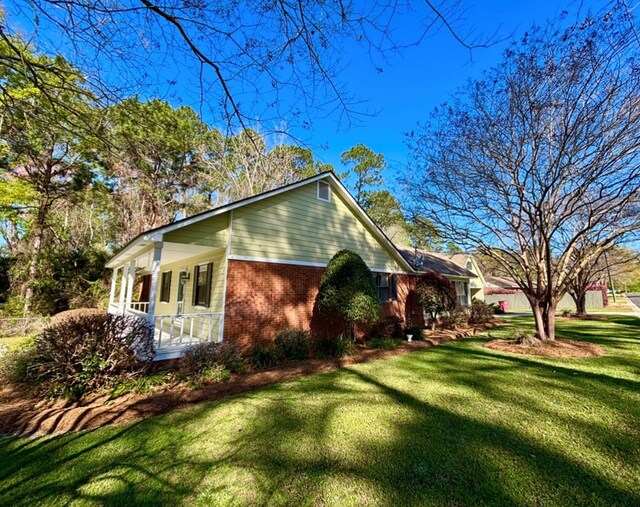 311 E 24th St, Tifton, GA 31794 - view of property exterior featuring a porch, a yard, and brick siding