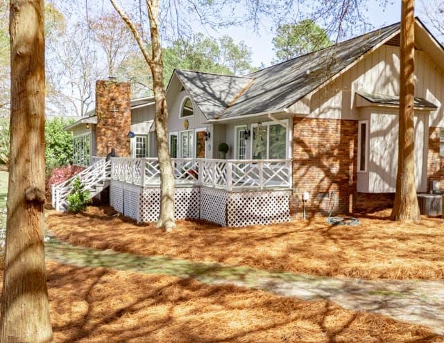 rear view of house featuring a deck and a chimney