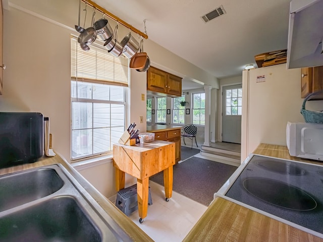 64 Palmetta Rd, Tifton, GA 31794 - kitchen with brown cabinets, ornate columns, white appliances, and extractor fan