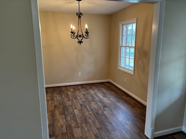 2019 N Central Ave, Tifton, GA 31794 - empty room with dark wood-type flooring, a chandelier, and baseboards