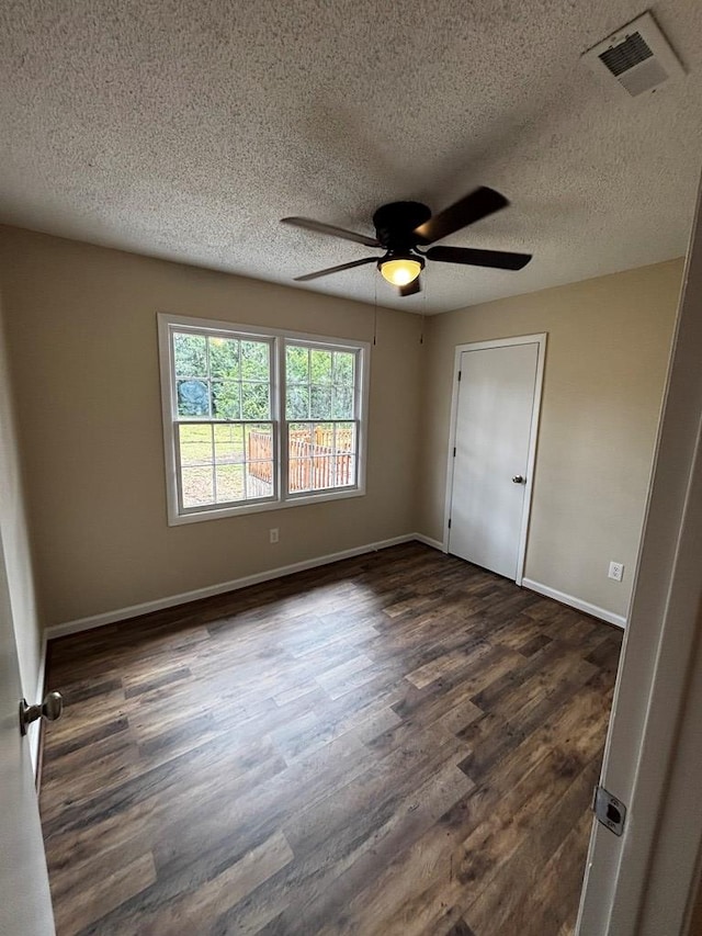2019 N Central Ave, Tifton, GA 31794 - unfurnished bedroom featuring dark wood finished floors, a textured ceiling, baseboards, and ceiling fan