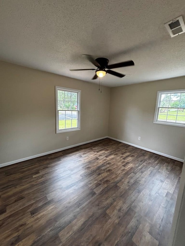 2019 N Central Ave, Tifton, GA 31794 - spare room with plenty of natural light, dark wood finished floors, a textured ceiling, a ceiling fan, and baseboards