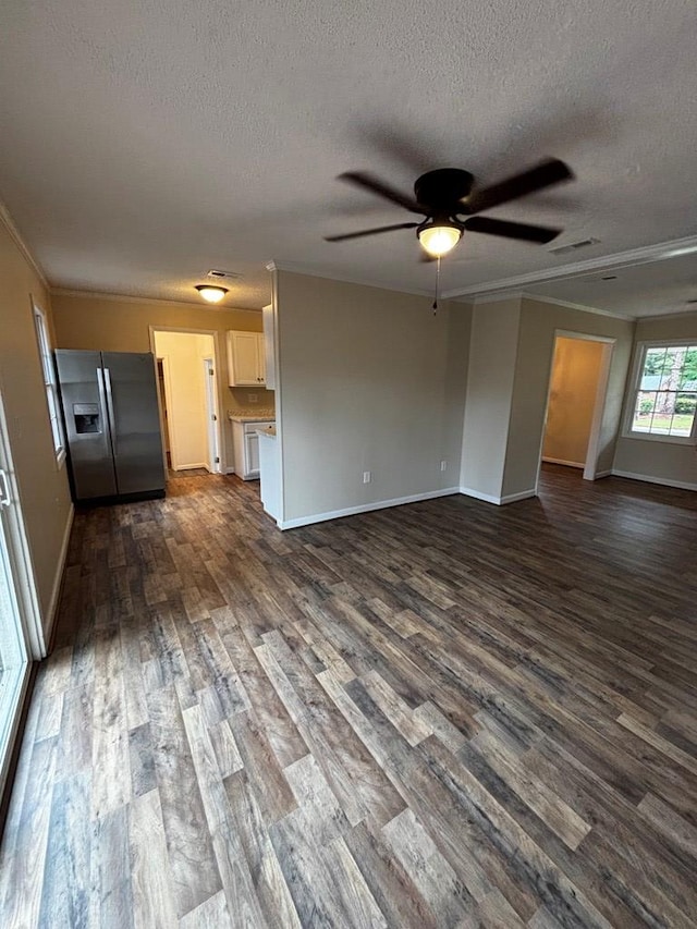 2019 N Central Ave, Tifton, GA 31794 - unfurnished living room featuring a textured ceiling, dark wood-style flooring, baseboards, ceiling fan, and ornamental molding