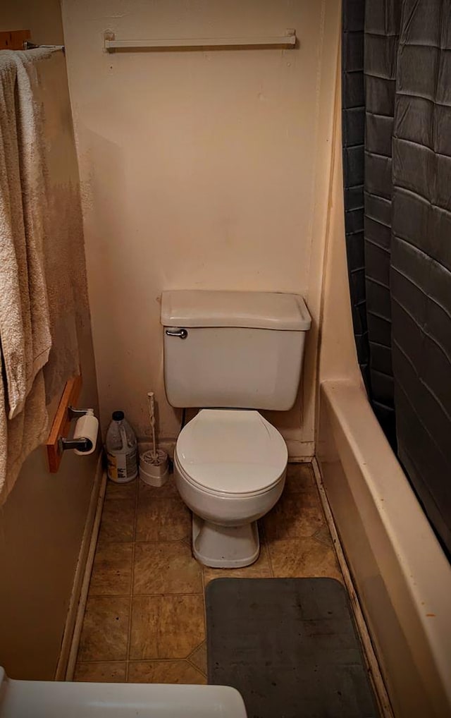 full bathroom featuring toilet and baseboards