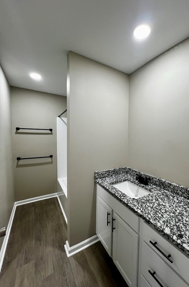 bathroom featuring baseboards, vanity, wood finished floors, and shower / bathtub combination