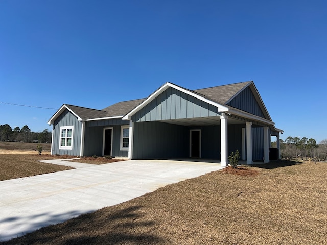 modern farmhouse style home featuring a shingled roof, driveway, and an attached carport