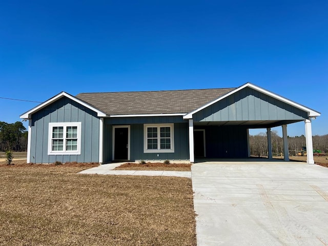 ranch-style house with a carport, a shingled roof, and driveway