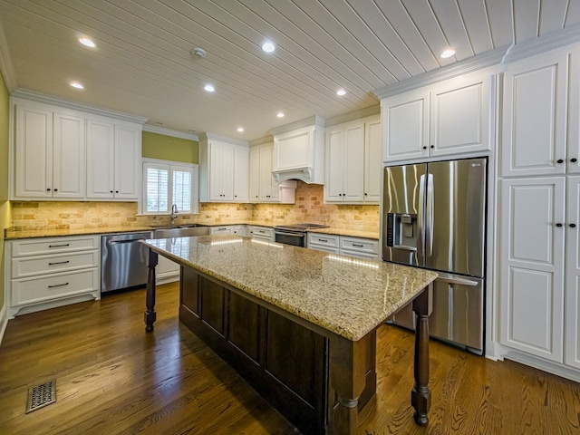 11 Fairway Dr, Tifton, GA 31793 - kitchen featuring visible vents, dark wood-style flooring, a kitchen bar, white cabinets, and appliances with stainless steel finishes