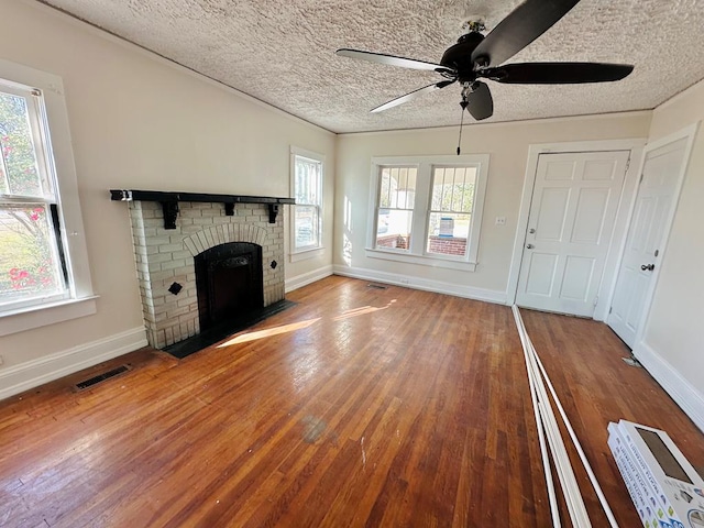 416 W 6th St, Tifton, GA 31794 - unfurnished living room with ceiling fan, a fireplace, visible vents, and hardwood / wood-style flooring