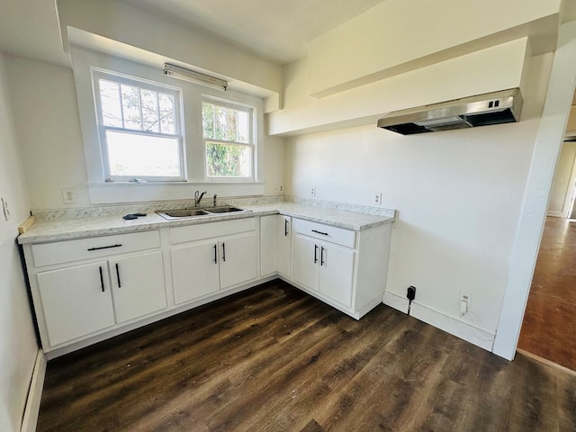 416 W 6th St, Tifton, GA 31794 - kitchen featuring white cabinetry, light stone countertops, under cabinet range hood, dark wood-type flooring, and a sink
