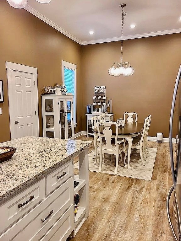 307 E Pinson St, Sylvester, GA 31791 - dining room featuring baseboards, a notable chandelier, ornamental molding, and light wood-type flooring