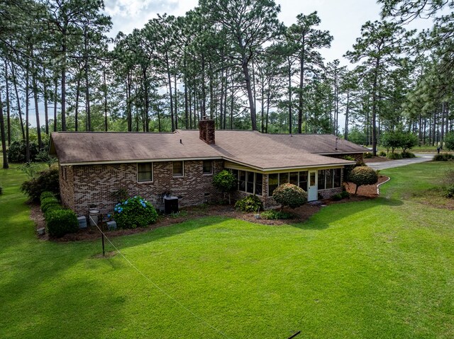 128 Airport Rd, Sylvester, GA 31791 - rear view of house featuring brick siding, a chimney, a yard, and roof with shingles