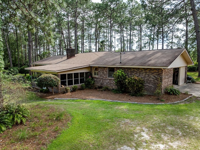 128 Airport Rd, Sylvester, GA 31791 - view of front facade featuring a chimney, a sunroom, brick siding, and a front lawn