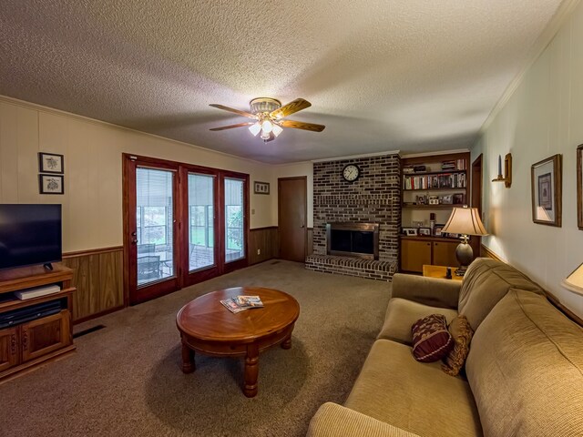 128 Airport Rd, Sylvester, GA 31791 - living room featuring a ceiling fan, a textured ceiling, wooden walls, a brick fireplace, and carpet