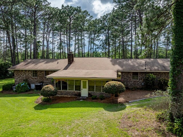 128 Airport Rd, Sylvester, GA 31791 - view of front facade featuring brick siding, a front yard, a chimney, and roof with shingles