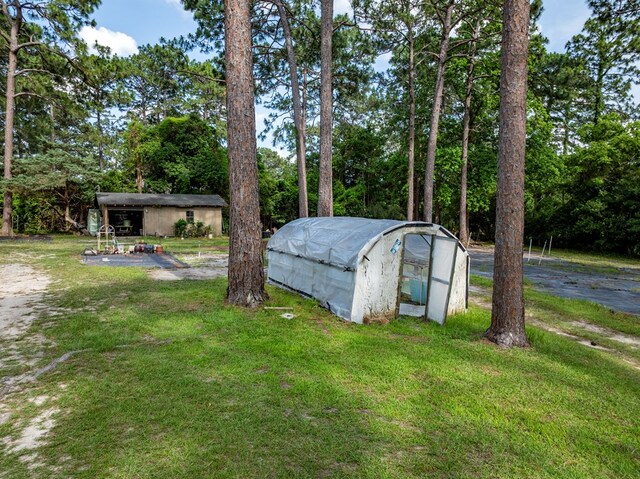 128 Airport Rd, Sylvester, GA 31791 - view of grassy yard with an exterior structure, an outbuilding, and view of scattered trees