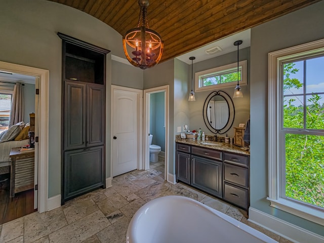 248 Gun Lake Loop, Tifton, GA 31794 - full bath with vaulted ceiling, a chandelier, vanity, stone tile floors, and a tub