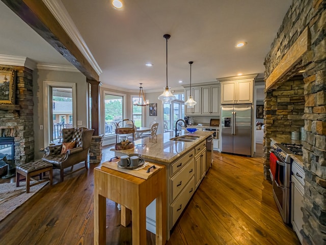 248 Gun Lake Loop, Tifton, GA 31794 - kitchen featuring stainless steel appliances, cream cabinetry, dark wood-style floors, ornamental molding, and a kitchen island with sink