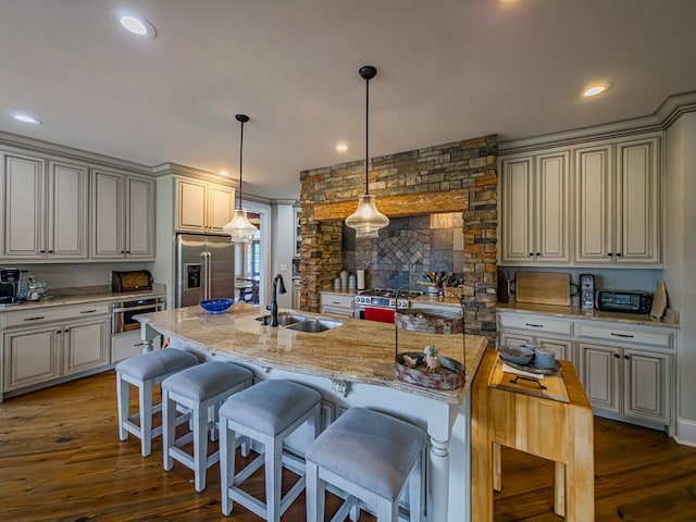 248 Gun Lake Loop, Tifton, GA 31794 - kitchen featuring stainless steel appliances, dark wood-style floors, light stone counters, pendant lighting, and a kitchen bar