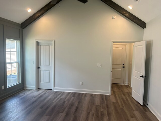 spare room with beamed ceiling, dark wood-type flooring, and baseboards