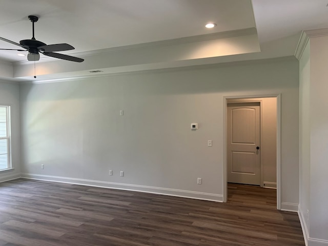 unfurnished room featuring a tray ceiling, ornamental molding, dark wood-style flooring, baseboards, and ceiling fan