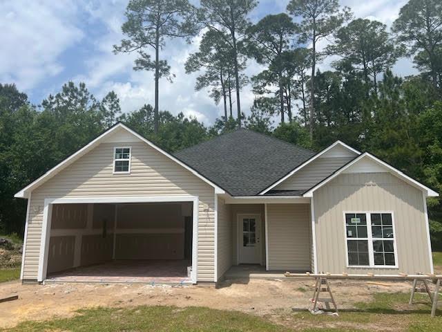 view of front of property featuring an attached garage and a shingled roof