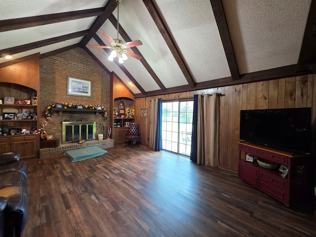 living area featuring a ceiling fan, wood walls, a fireplace, wood finished floors, and a textured ceiling