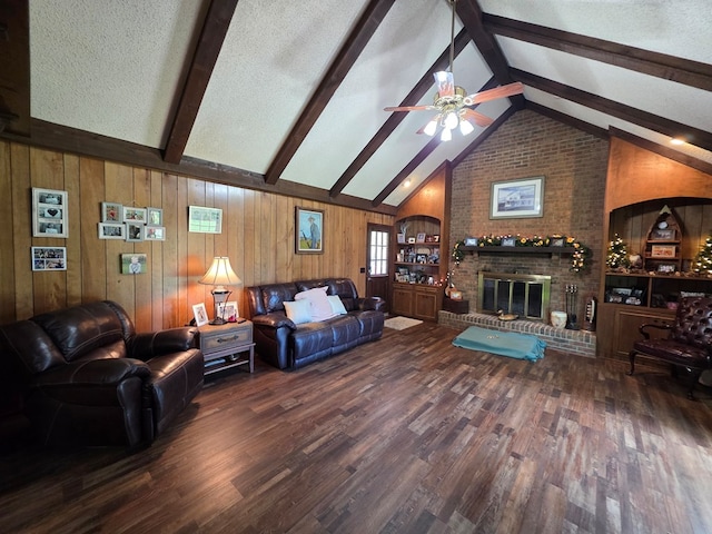 living room with wood finished floors, wooden walls, a ceiling fan, and a brick fireplace