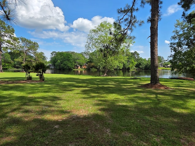 view of green lawn with a water view