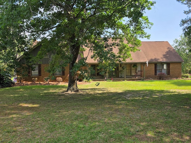 back of house featuring a yard and brick siding