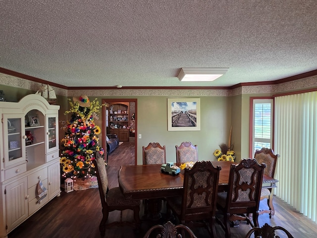 dining space with a textured ceiling, dark wood-style floors, and crown molding