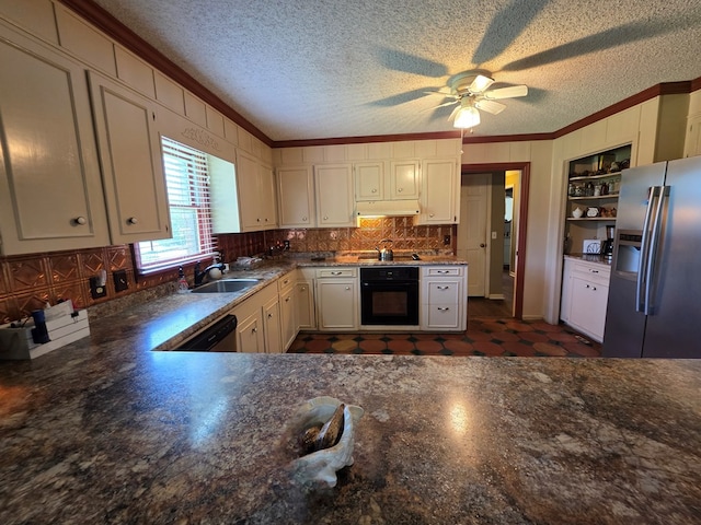 kitchen featuring stainless steel fridge, black oven, crown molding, a sink, and tasteful backsplash