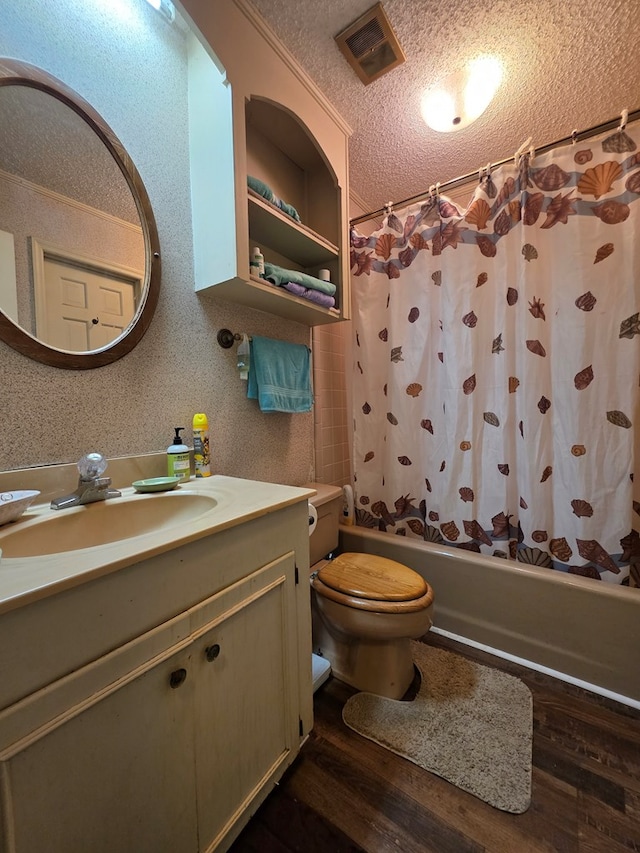 full bath featuring wood finished floors, a textured ceiling, shower / bathtub combination with curtain, vanity, and toilet