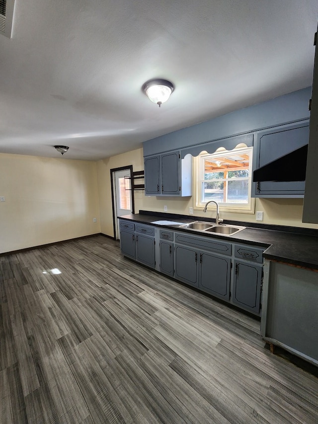 kitchen with a sink, dark countertops, visible vents, gray cabinets, and dark wood-type flooring
